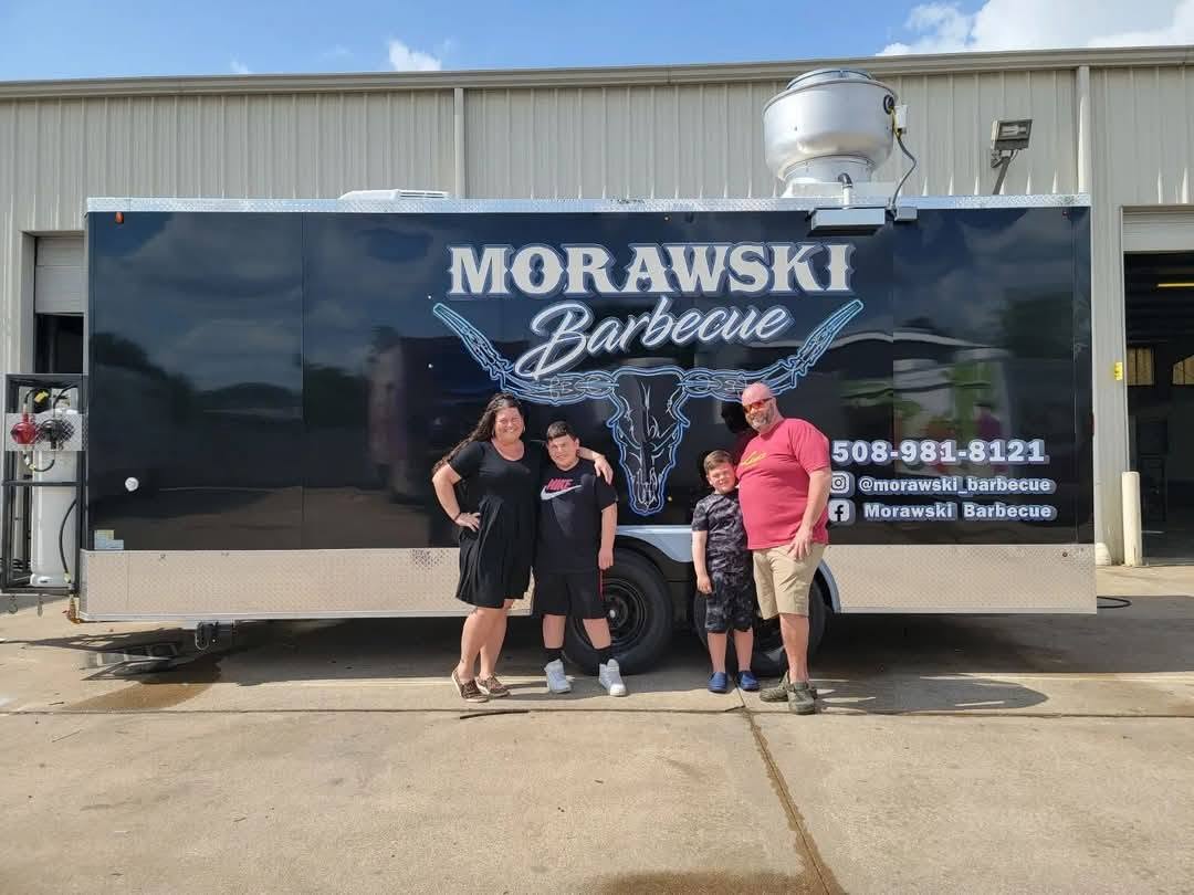 Andrew and Cherise Morawski standing beside their barbecue trailer